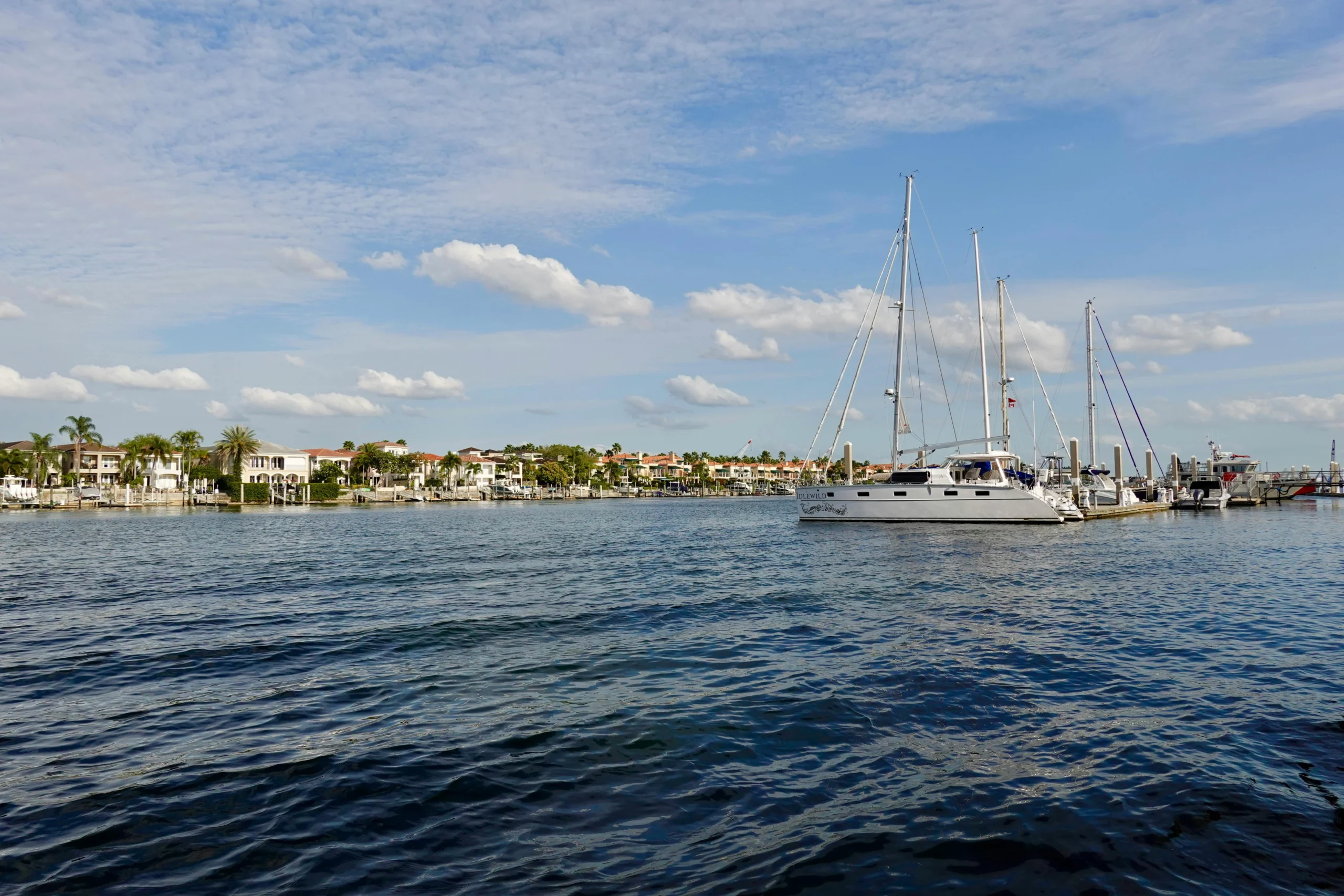 Boats anchored off the coast of Pinellas County in Florida with coastline homes in the background
